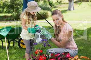 Mother with daughter watering plants