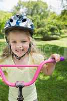 Close-up of a little girl on a bicycle at park