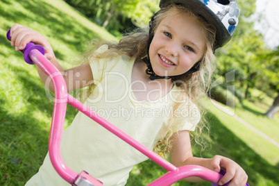 Little girl on a bicycle at summer park