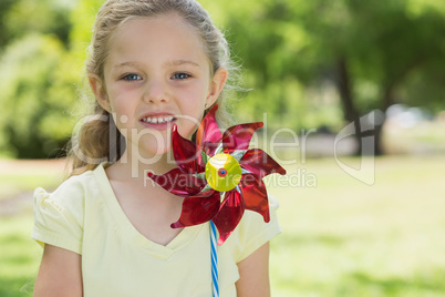 Portrait of cute girl holding pinwheel at park