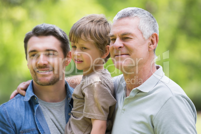 Grandfather father and son smiling at park