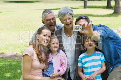 Man taking picture of extended family at park