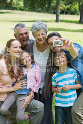 Man taking picture of extended family at park