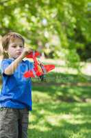 Cute boy with toy aeroplane at park