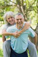 Happy mature man carrying woman at park