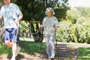 Mature couple Nordic walking at park