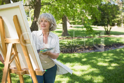 Mature woman painting in park