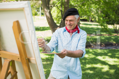 Mature man painting in park