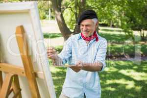 Mature man painting in park