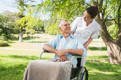 Woman with her father sitting in wheel chair at park