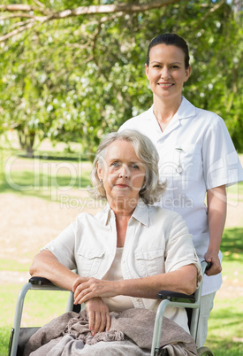 Woman with her mother sitting in wheel chair at park