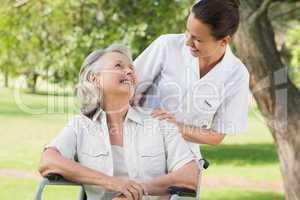Woman with her mother sitting in wheel chair at park