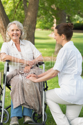 Woman with her mother sitting in wheel chair at park