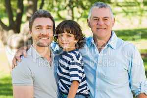 Grandfather father and son smiling at park