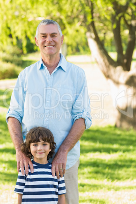 Grandfather and son standing at park