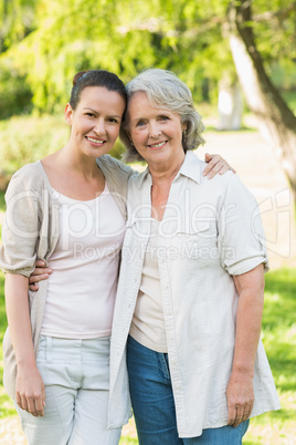 Portrait of smiling woman with adult daughter at park