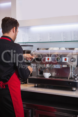 Handsome barista making a cup of coffee