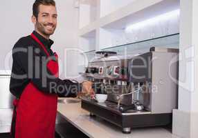 Smiling young barista making cup of coffee