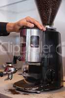 Barista using coffee grinder to grind beans