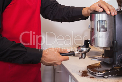 Barista using coffee grinder to grind coffee beans