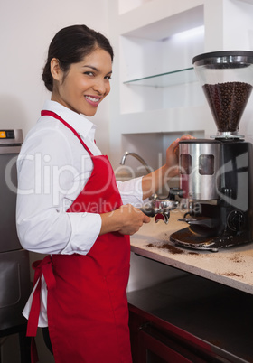 Pretty barista grinding up coffee beans