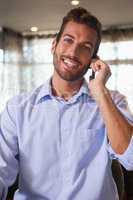 Happy businessman talking on the phone after work