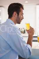 Handsome businessman drinking glass of beer after work