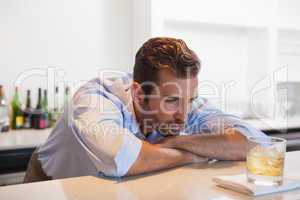 Drunk businessman staring at his whiskey glass