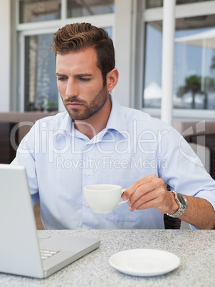 Concentrating businessman working with laptop at table