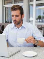 Concentrating businessman working with laptop at table