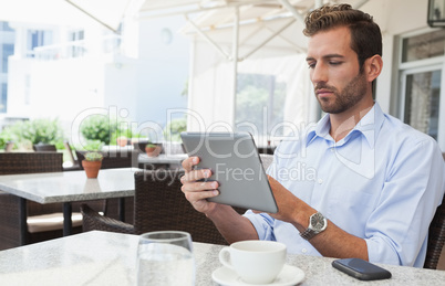 Focused young businessman working on tablet