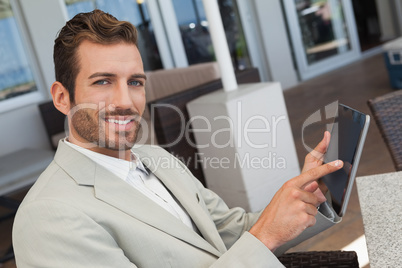 Cheerful young businessman working with digital tablet