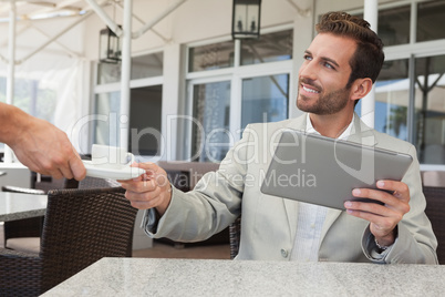 Cheerful businessman working with digital tablet taking his espr