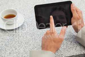 Businessman using small tablet at table