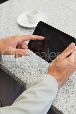 Businessman using a small tablet at table