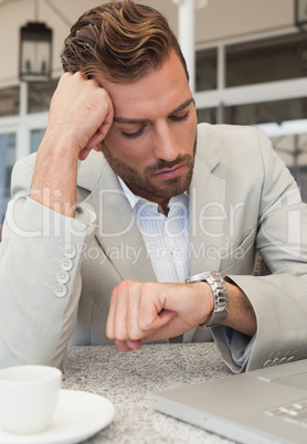 Frowning businessman looking at his watch