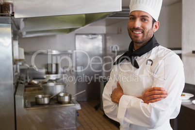 Happy head chef smiling at camera with arms crossed