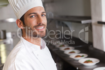 Cheerful young chef smiling at camera