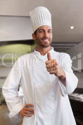 Cheerful young chef looking at camera showing thumb up