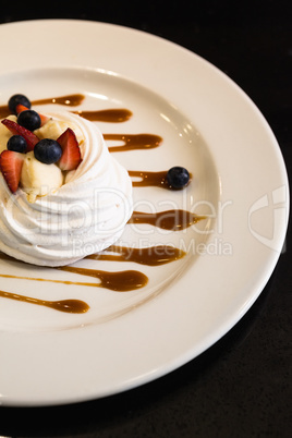 Meringue dessert with fruit and sauce