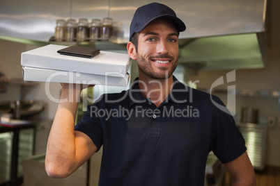 Smiling pizza delivery man holding two pizza boxes