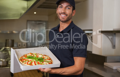 Happy pizza delivery man showing fresh pizza
