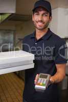 Happy pizza delivery man showing credit card machine