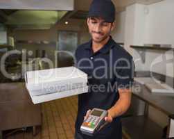 Happy pizza delivery man holding credit card machine