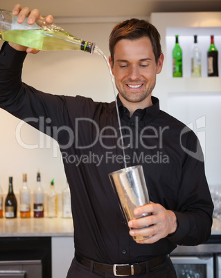 Happy bartender preparing a cocktail