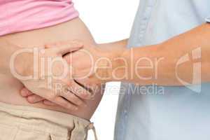 Expectant father touching mothers baby bump