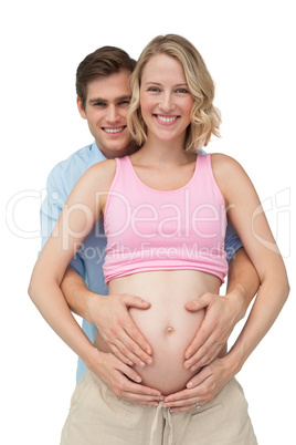 Expectant happy parents making a heart shape on mothers baby bum