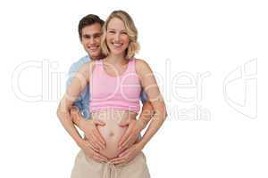 Expectant smiling parents holding mothers baby bump