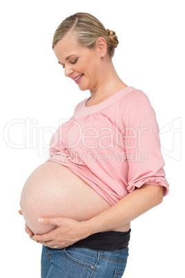 Happy pregnant woman looking down at her bump