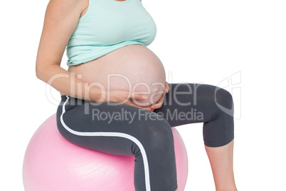 Pregnant woman sitting on pink exercise ball